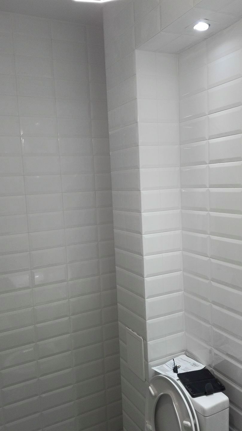 Łazienka białe kafelki 10x20, płytki patchwork na podłodze, kabina prysznicowa z brodzikiem