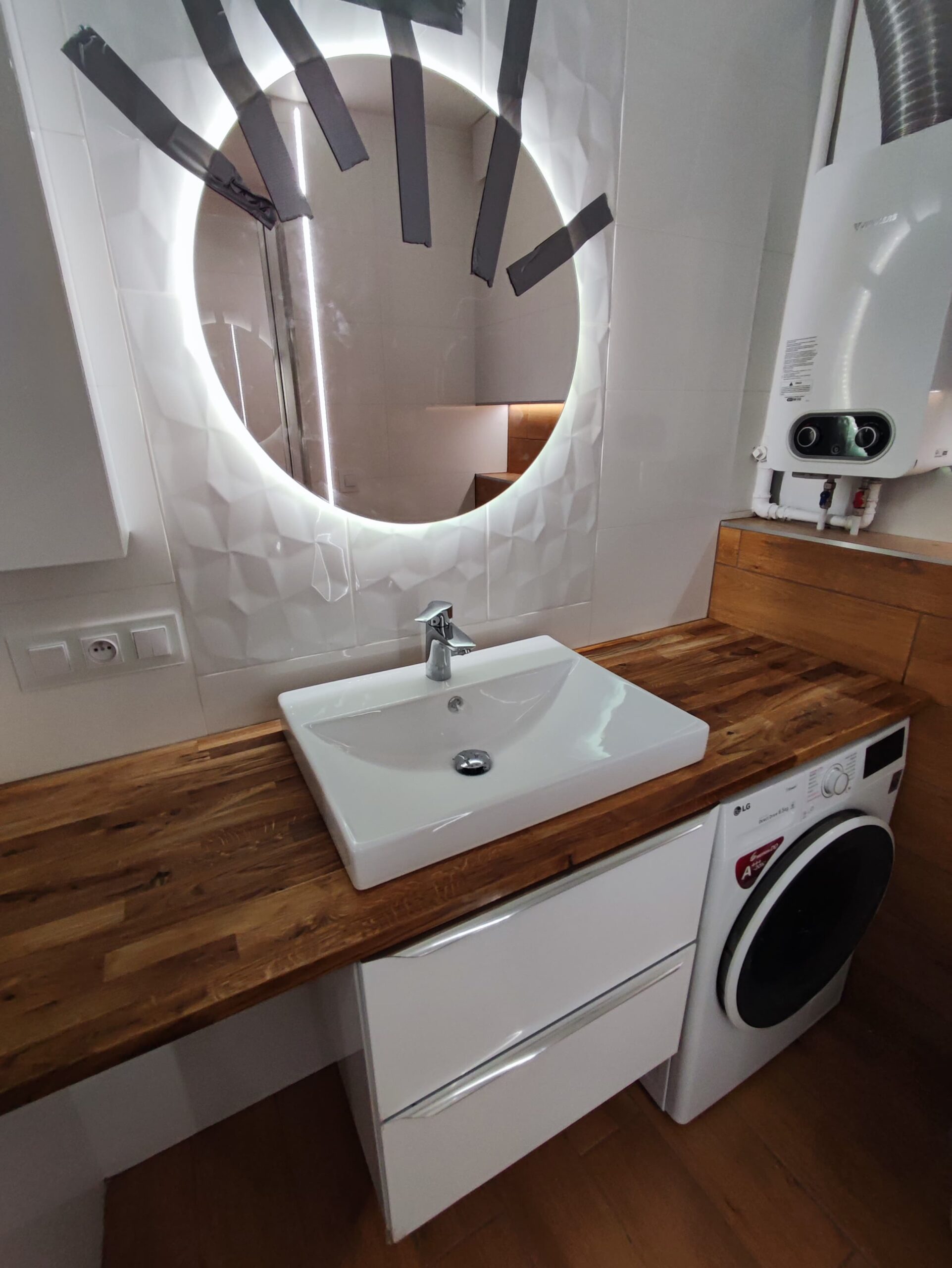 Białe płytki oraz panele drewnopodobne - remont łazienki